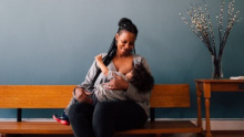 Mum sitting on a bench breastfeeding baby